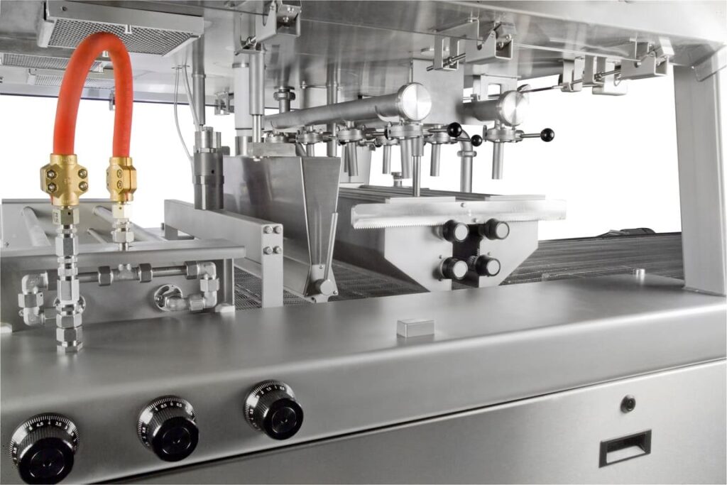 Aasted Nielsen Master Enrober, engineered for precision chocolate coating, ensuring seamless enrobing of confectionery products with a consistent and high-quality finish