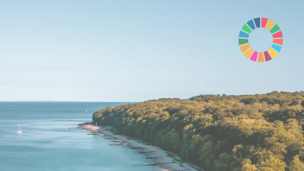 Scenic coastline with the UN Sustainable Development Goals (SDG) logo – representing Aasted's commitment to sustainability and environmental responsibility